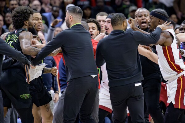 New Orleans Pelicans forward Naji Marshall, left, and Miami Heat forward Jimmy Butler, right, are separated during a scuffle in he second half of an NBA basketball game in New Orleans, Friday, Feb. 23, 2024. Marshall and Butler were later ejected. (AP Photo/Matthew Hinton)