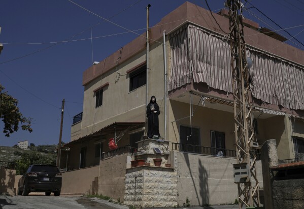 A statue of Saint Rafqa is displayed in front of a residential building in the village of Quraye, near the southern port city of Sidon, Lebanon, Thursday, April 17, 2025. (AP Photo/Hassan Ammar)