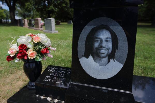 FILE - In this July 6, 2017, file photo, a bouquet of flowers adorns the grave of Philando Castile at Calvary Cemetery in St. Louis. Minnesota's attorney general says a St. Paul professor who led a campaign to pay off student lunch debts in Castile’s name spent less than half of the $200,000 she raised on the intended purpose. (David Carson/St. Louis Post-Dispatch via AP, File)