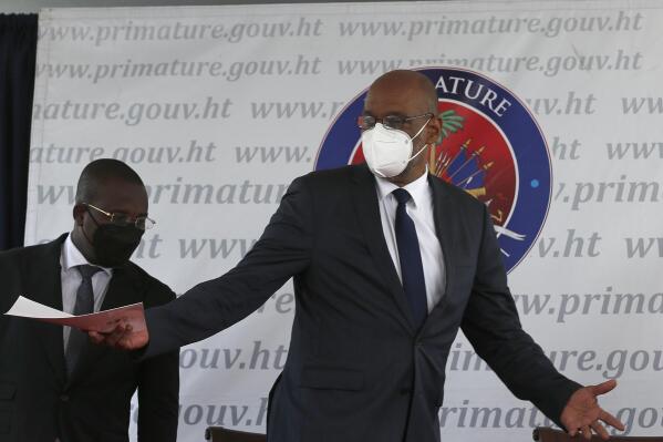 ARCHIVO - En esta fotografía del 20 de julio de 2021, el primer ministro de Haití, Ariel Henry, abre los brazos durante una ceremonia en Puerto Príncipe. (AP Foto/Joseph Odelyn, archivo)