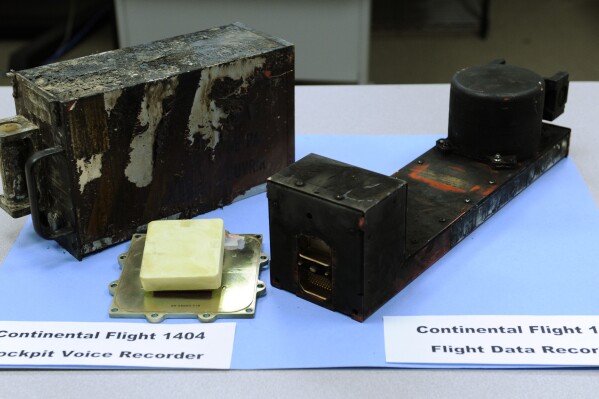 FILE - The cockpit voice recorder, left, and the flight data recorder from Continental flight 1404 airplane accident on display at the National Transportation Safety Board headquarters in Washington, Dec. 22, 2008. Federal accident investigators are pushing for better cockpit voice recorders. They are pointing to limits of the device on the jetliner that suffered a door-panel blowout last month over Oregon. The National Transportation Safety Board said Tuesday, Feb. 13, 2024 that the Federal Aviation Administration should require all current planes to have recorders that can capture 25 hours of audio, up from the current standard of two hours. (AP Photo, file)