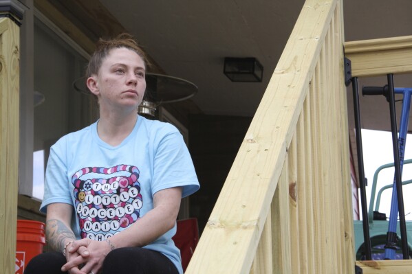 Emily Russell sits on the newly constructed staircase leading up to the front of her home in Swannanoa, N.C., on Thursday, Feb. 6, 2025. (AP Photo/Makiya Seminera)