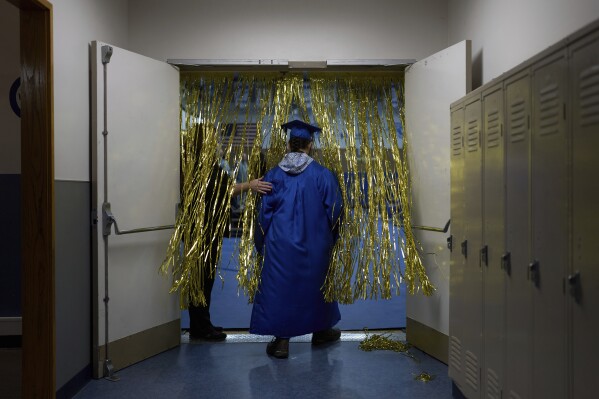 A student from the Galena Interior Learning Academy enters a gym during a graduation ceremony for the school Wednesday, May 21, 2025, in Galena, Alaska. (AP Photo/John Locher)