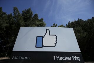 FILE - In this April 14, 2020 file photo, the thumbs up Like logo is shown on a sign at Facebook headquarters in Menlo Park, Calif.  Facebook said Tuesday, Sept. 1 that it removed a small network of accounts and pages linked to Russia's Internet Research Agency, the “troll factory" that has used social media accounts to sow political discord in the U.S. since the 2016 presidential election.  (AP Photo/Jeff Chiu, File)