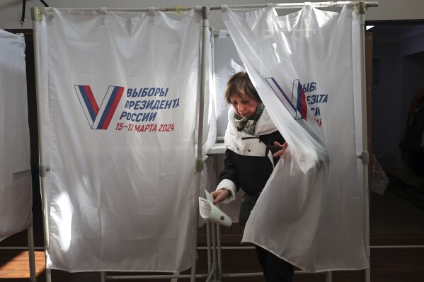 A woman leaves a voting booth at a polling station in the Pacific Higher Naval School during a presidential election in the Pacific port city of Vladivostok, east of Moscow, Russia, Friday, March 15, 2024. Voters in Russia are heading to the polls for a presidential election that is all but certain to extend President Vladimir Putin's rule after he clamped down on dissent. (AP Photo)