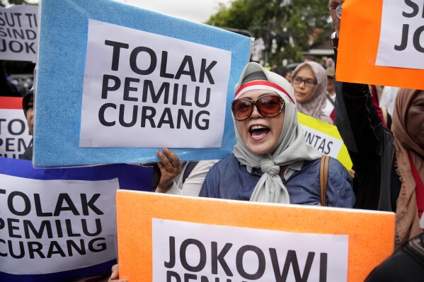 A protester shouts slogans during a rally against alleged fraud in the Feb. 14 presidential election outside the General Election Commission's office in Jakarta, Indonesia, Friday, Feb. 16, 2024. Tens of people staged the rally demanding the election authority to stop presidential frontrunner Prabowo Subianto, a former general who has claimed victory after unofficial tallies put him in the lead, from taking office as the next president, claiming widespread electoral fraud. Writings on the posters read 