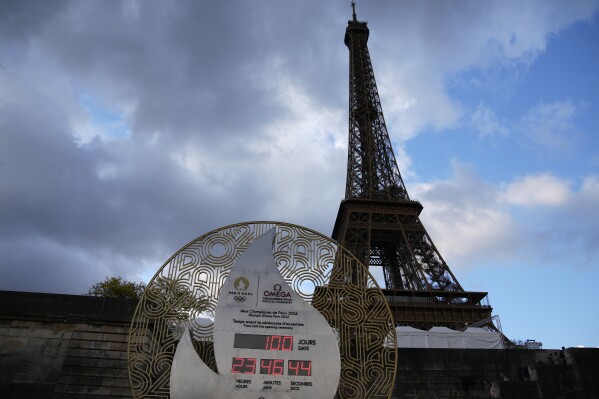 The countdown clock, set up on the banks of the Seine river and in front of the Eiffel Tower, reads 100 days before the Paris 2024 Olympic Games opening ceremony,Tuesday, April 16, 2024 in Paris. The Paris 2024 Olympic Games will run from July 26 to Aug. 11(AP Photo/Christophe Ena)