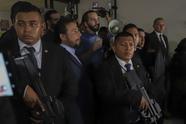 Members of the presidential security command surround El Salvador's President Nayib Bukele, center, during their speech to supporters in San Salvador, El Salvador, Friday, Oct. 27, 2023. (AP Photo/Salvador Melendez)