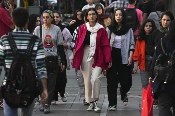 Iranian women, some without wearing their mandatory Islamic headscarves, walk in downtown Tehran, Iran, Saturday, Sept. 9, 2023. Iranians are marking the first anniversary of nationwide protests over the country's mandatory headscarf law that erupted after the death of a young woman detained by morality police. (AP Photo/Vahid Salemi)