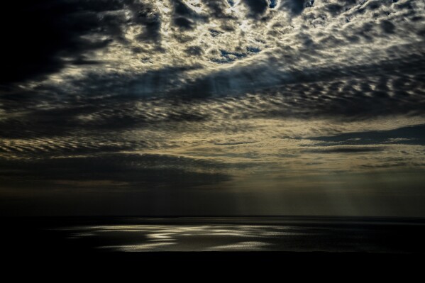 FILE - Light is reflected on part of the Aral Sea outside Muynak, Uzbekistan, June 25, 2023. Researchers at the National Oceanic and Atmospheric Administration and NASA believe if they can inject ice high up in the air, water vapor, water in its gas form, in the upper atmosphere would get a bit drier and that could cool Earth. (AP Photo/Ebrahim Noroozi, File)