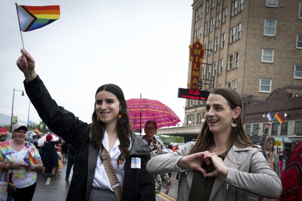 Rep. Zooey Zephyr, right, and her fiancée Erin Reed wave at folks lined up along Higgins Avenue in downtown Missoula, Mont., during the 2023 Missoula Pride Parade on Saturday, June 17, 2023. They have emerged as a power couple offering support for the transgender community during a year in which hundreds of statehouse bills were proposed or passed to restrict their rights in health care and other realms. (Antonio Ibarra Olivares/The Missoulian via AP)