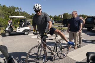 President Joe Biden gets back on his bike after he fell when he tried to get off his bike to greet a crowd at Gordons Pond in Rehoboth Beach, Del., Saturday, June 18, 2022. A fabricated screenshot purporting to show an article with a headline describing the fall as "heroism" has since spread online. (AP Photo/Manuel Balce Ceneta)