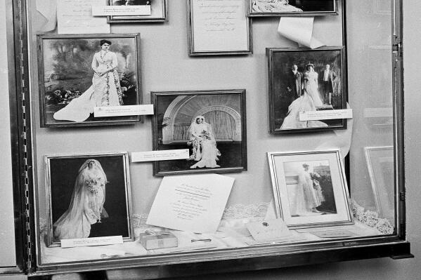 FILE - Photographs of brides married in the White House are displayed in the executive mansion in a glass-enclosed case in Washington, Aug. 1, 1966 prior to Saturday wedding of Luci Baines Johnson, President Johnson's youngest daughter. Down the left side of the frame, top the bottom, are: President James Monroe's daughter, Maria; President Rutherford B. Haye's niece, Emily Platt, Miss Frances Folsom, married to President Grover Cleveland; and President Woodrow Wilson's daughter, Eleanor. At center, President Wilson's daughter, Jessie. At right, top to bottom: President U.S. grant's daughter, Nellie; President Theodore Roosevelt's daughter, Alice; and President Wilson's niece, Alice Wilson. (AP Photo)