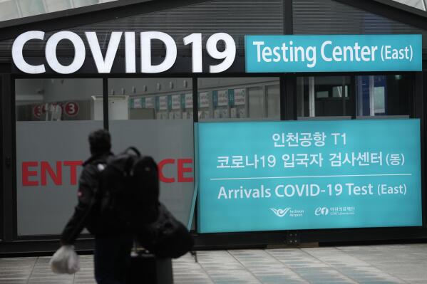 A traveler walks outside of a COVID-19 testing center at the Incheon International Airport In Incheon, South Korea, Friday, Feb. 10, 2023. South Korea says it will remove the entry restrictions it placed on short-term travelers from China since the start of the year as officials see the COVID-19 situation in that country as stabilizing. (AP Photo/Lee Jin-man)