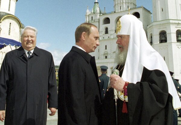 FILE - Russian Orthodox Patriarch Alexi II, right, greets Russian President Vladimir Putin as former President Boris Yeltsin looks on, in Moscow's Kremlin on May 7, 2000. (Sputnik, Kremlin Pool Photo via AP, File)