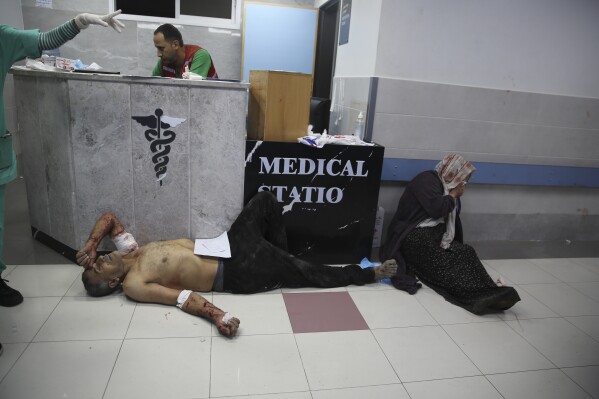 Palestinians wounded in Israeli strikes wait to be seen at Shifa Hospital in Gaza City on Wednesday, Oct. 11, 2023. (AP Photo/Ali Mahmoud)