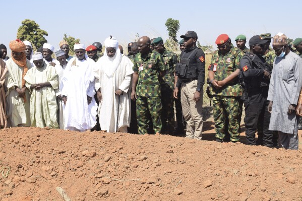 FILE - Nigeria Chief of Army Staff Lieutenant General Taoreed Lagbaja, center, with other Community leaders pray at the grave side were victims of an army drones attack were buried in Tudun Biri village Nigeria, on Dec. 5, 2023. Two Nigerian military personnel will face a court martial over the killing of 85 villagers in a military drone attack in December in the West African nation’s conflict-battered north, authorities said on Thursday May 2, 2024. (AP Photo Kehinde Gbenga, File)