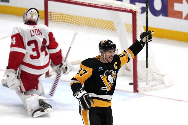 Pittsburgh Penguins' Sidney Crosby (87) celebrates after his goal as Detroit Red Wings goaltender Alex Lyon (34) collects himself during the first period of an NHL hockey game in Pittsburgh, Sunday, March 17, 2024. (AP Photo/Gene J. Puskar)