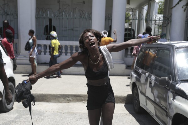 A woman shouts out how her family members died at the hands of gangs members in the Carrefour-Feuilles neighborhood, during a protest against insecurity in Port-au-Prince, Haiti, Friday, Aug. 25, 2023. (AP Photo/Odelyn Joseph)