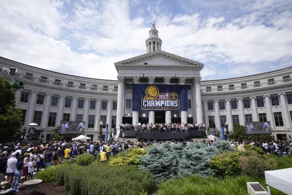 Members of the Denver Nuggets crowd the stage during a rally and parade to mark the team's first NBA basketball championship on Thursday, June 15, 2023, in Denver. (AP Photo/David Zalubowski)