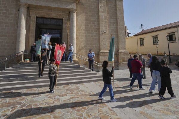 Worshippers follow a traditional procession on the Feast Day of St. George outside St. George Church in the Maronite village of Kormakitis in the breakaway north of the ethnically divided Cyprus on Wednesday, April 23, 2025. (AP Photo/Petros Karadjias)