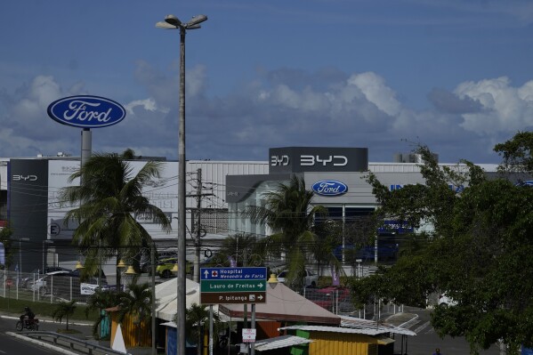Signs are displayed for dealerships for BYD and Ford in Camacari, Bahia state, Brazil, Friday, March 7, 2025. (AP Photo/Eraldo Peres)