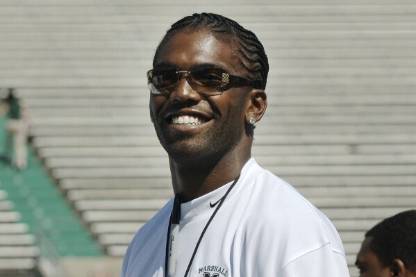 FILE - Former Marshall football player Randy Moss of the Oakland Raiders waves to fans prior to serving as an honorary coach during Marshall's annual Green-White game Saturday, April 22, 2006, in Huntington, W.Va. Moss and Larry Fitzgerald were among 19 players and three coaches in the latest College Football Hall of Fame class announced Monday. (AP Photo/Jeff Gentner, File)