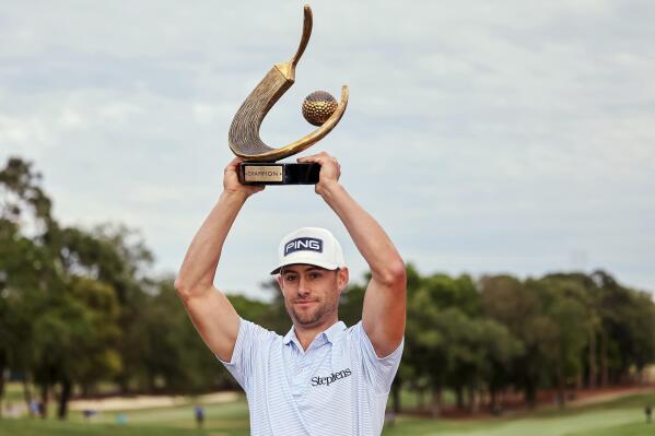 Taylor Moore holds up the trophy after winning the Valspar Championship golf tournament Sunday, March 19, 2023, at Innisbrook in Palm Harbor, Fla. (AP Photo/Mike Carlson)
