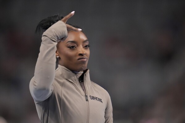 Simone Biles gestures during introductions for the U.S. Gymnastics Championships Sunday, June 2, 2024, in Fort Worth, Texas. (AP Photo/Julio Cortez)