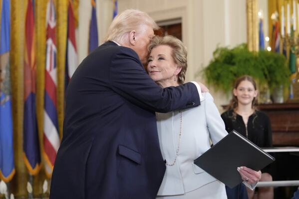 President Donald Trump, left, hugs Secretary of Education Linda McMahon after he signed an executive order in the East Room of the White House in Washington, Thursday, March 20, 2025. (AP Photo/Ben Curtis)