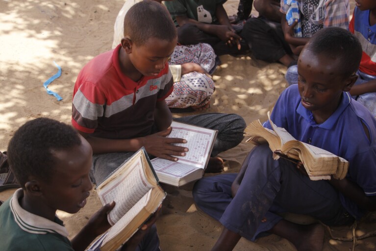 Children, who fled amid drought, read the Quran at a makeshift camp for the displaced people on the outskirts of Mogadishu, Somalia on Thursday, Sept. 26, 2023. (AP Photo/Farah Abdi Warsameh)