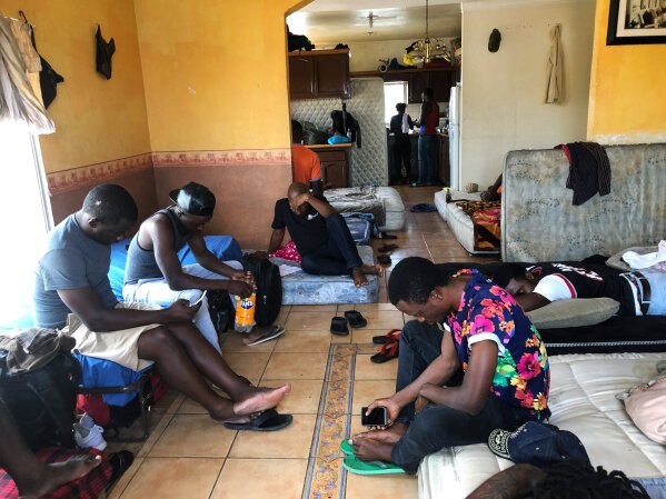 FILE - In this July 28, 2019, file photo, Cameroonians wait in a rented apartment in Tijuana, Mexico, until their names are called to claim asylum in the U.S.  President Donald Trump isn't the only world leader making it virtually impossible for many Africans to get asylum in the United States.  Ecuador is closing its doors as one of the few countries in North and South America to welcome African visitors, depriving them of a starting point for their dangerous journeys north by land.  (AP Photo/Elliot Spagat, File)
