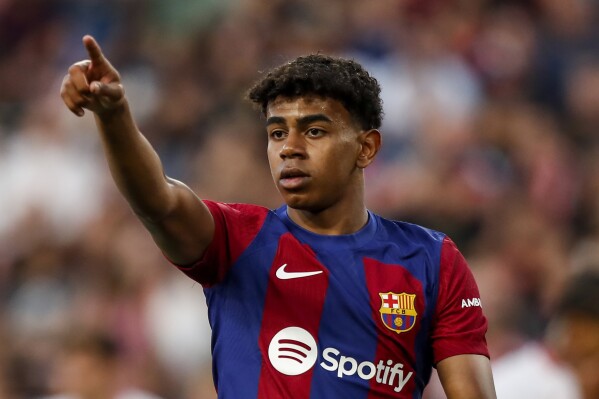 FILE - Barcelona's Lamine Yamal gestures during a Spanish La Liga soccer match between Sevilla and FC Barcelona at the Ramon Sanchez Pizjuan stadium in Seville, Spain, on May 26, 2024. Spain's hopes of making a deep run at the European Championship will rest on a pair of young, fast forwards. (AP Photo/Fermin Rodriguez, File)