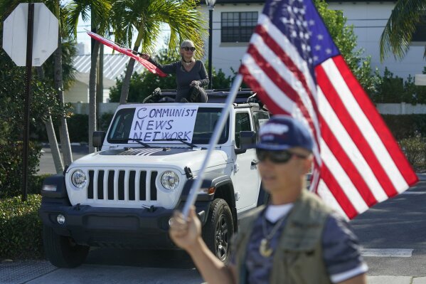 Supporters of President Donald Trump watch his motorcade drive by in West Palm Beach, Fla., Sunday, Dec. 27, 2020. Trump is en route to his Mar-a-Lago resort in Palm Beach, Fla., after visiting Trump International Golf Club. (AP Photo/Patrick Semansky)