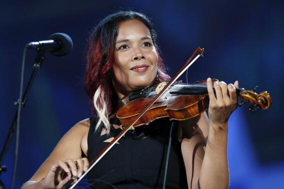 FILE - Rhiannon Giddens performs during rehearsal for the Boston Pops Fireworks Spectacular in Boston, on July 3, 2018. Giddens will participate in an online fundraiser for the environment that will be shown on YouTube. The organization Playing for Change is putting on the event in collaboration with the United Nations Population Fund. (AP Photo/Michael Dwyer, File)
