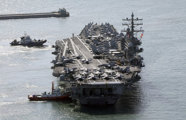 U.S. nuclear-powered aircraft carrier USS Ronald Reagan is escorted as it arrives in Busan, South Korea, Thursday, Oct. 12, 2023. (Kang Duck-chul/Yonhap via AP)