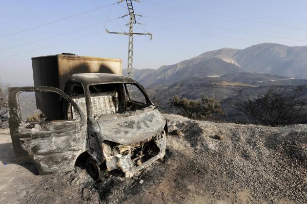 FILE - A charred truck is pictured after a fire near the village of Achlouf, in the Kabyle region, east of Algiers, Friday, Aug. 13, 2021. An Algerian court sentenced 49 people to death Thursday, Nov. 24, 2022 for the brutal mob killing of a painter wrongly suspected of starting devastating wildfires. In fact the man had come to help fight the fires. The 49 people will likely serve life in prison instead because Algeria has a moratorium on executions. (AP Photo/Toufik Doudou, File)