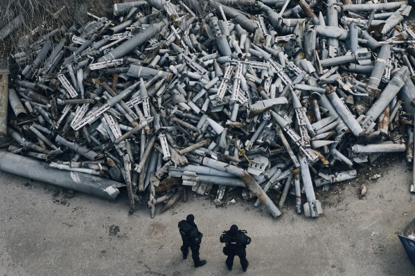 FILE - Police officers look at collected fragments of the Russian rockets, including cluster rounds, that hit Kharkiv, in Kharkiv, Ukraine, on Dec. 3, 2022. Backers of an international agreement that bans cluster munitions are striving to prevent erosion in support for it after what one leading human rights group calls an “unconscionable” U.S. decision to ship such weapons to Ukraine for its fight against Russia. Advocacy groups in the Cluster Munitions Coalition released their latest annual report on Tuesday Sept. 5, 2023. (AP Photo/Libkos, File)