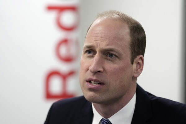 FILE - Britain's Prince William, The Prince of Wales, listens as he visits the British Red Cross at its headquarters in London, Tuesday, Feb. 20, 2024. Kensington Palace says Britain's Prince William has pulled out of attending a memorial service for his godfather, the late King Constantine of Greece, because of a personal matter. (AP Photo/Kin Cheung, Pool, File)