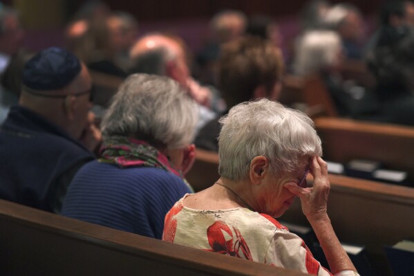 Anne Faigen, right, says a silent prayer for her friends in Israel while at a Shabbat service at Temple Sinai in Pittsburgh on Friday, Oct. 13, 2023. (AP Photo/Jessie Wardarski)