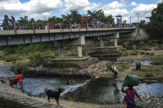 FILE - People bathe in the Massacre River, named for a bloody battle between Spanish and French colonizers in the 1700s, on the border with Haiti in Ouanaminthe, Dominican Republic, Nov. 19, 2021. The Dominican Republic's President Luis Abinader announced on Sept. 11, 2023 he has suspended issuing visas to Haitians. (AP Photo/Matias Delacroix, File)