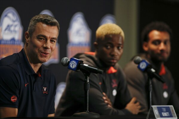 Virginia coach Tony Bennett, left, answers a question as players Mamadi Diakite, center, and Braxton Key look on during the Atlantic Coast Conference NCAA college basketball media day in Charlotte, N.C., Tuesday, Oct. 8, 2019. (AP Photo/Nell Redmond)