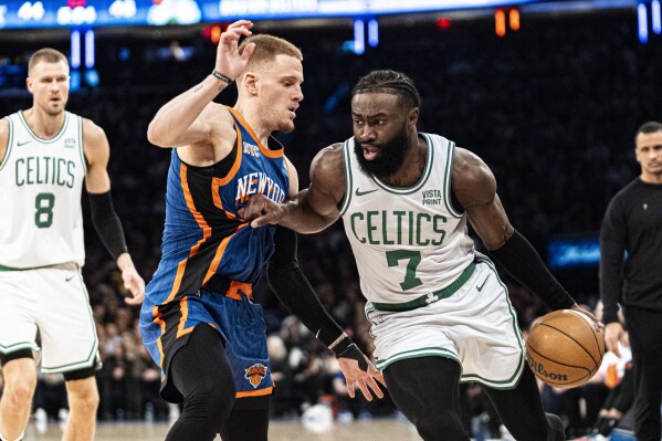 Boston Celtics guard Jaylen Brown (7) drives to the basket against New York Knicks guard Donte DiVincenzo, center left, during the first half of an NBA basketball game in New York, Saturday, Feb. 24, 2024. (AP Photo/Peter K. Afriyie)