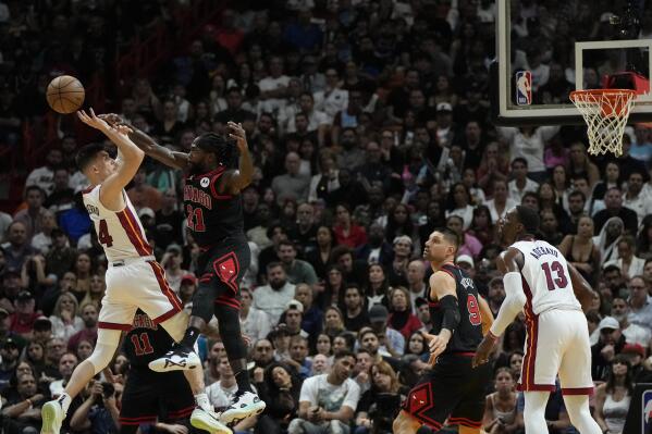 Miami Heat guard Tyler Herro (14) is fouled by Chicago Bulls guard Patrick Beverley (21) as he shoots during the second half of an NBA basketball play-in tournament game, Friday, April 14, 2023, in Miami. (AP Photo/Rebecca Blackwell)