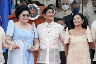 FILE - President Ferdinand Marcos Jr. stands with his mother Imelda Marcos, left, and his wife Maria Louise Marcos, right, during his inauguration ceremony to become the country's 17th president at the National Museum in Manila, Philippines, on June 30, 2022. Former Philippine first lady Imelda Marcos, the mother of the incumbent president and widow of an ousted dictator, has been hospitalized with pneumonia. President Ferdinand Marcos Jr said on Tuesday March 5, 2024 that his mother, who is 94, was suffering from a slight pneumonia and was put on antibiotics by her doctors. (AP Photo/Aaron Favila, File)