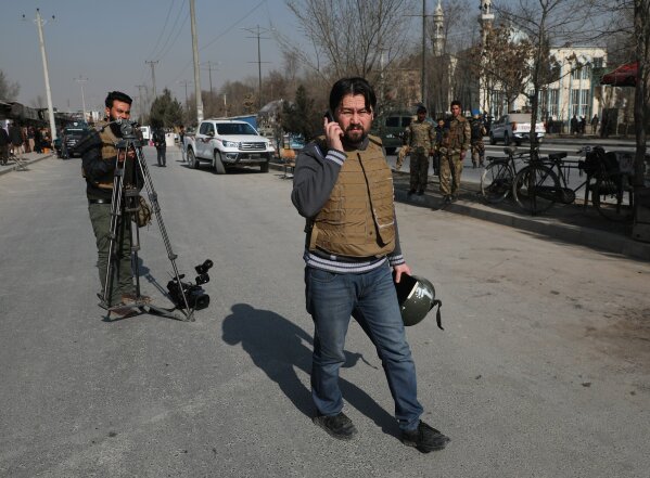 Zabiullah Doorandish, center, who works for a local TV channel in Kabul, arrives at the site of a blast in Kabul, Afghanistan, Tuesday, Feb. 9, 2021. Doorandish survived a roadside bomb attack by the Islamic State last May. He says now he lives much of the time in fear. Like many journalists he gets death threats, but he says he isn't sure who is behind them, even though some say they are Taliban. (AP Photo/Rahmat Gul)