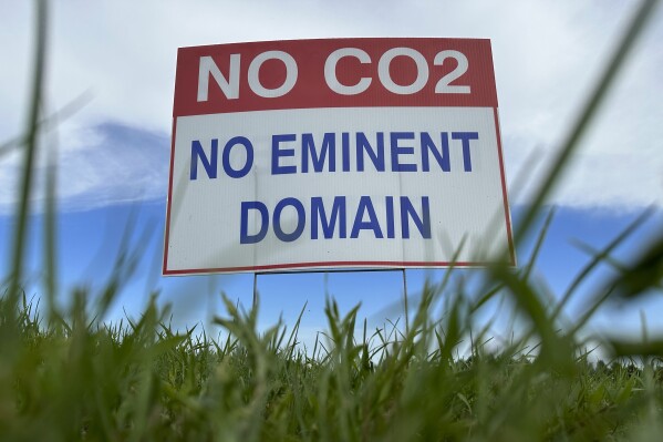 FILE - A sign reading "No CO2, no eminent domain" stands along a rural road east of Bismarck, N.D., on Aug. 15, 2023. Navigator CO2 Ventures on Friday, Oct. 20, 2023, said it would cancel its plans for a 1,300-mile pipeline across five Midwestern states to gather carbon dioxide emissions from ethanol plants and bury the gas deep underground. (AP Photo/Jack Dura, File)