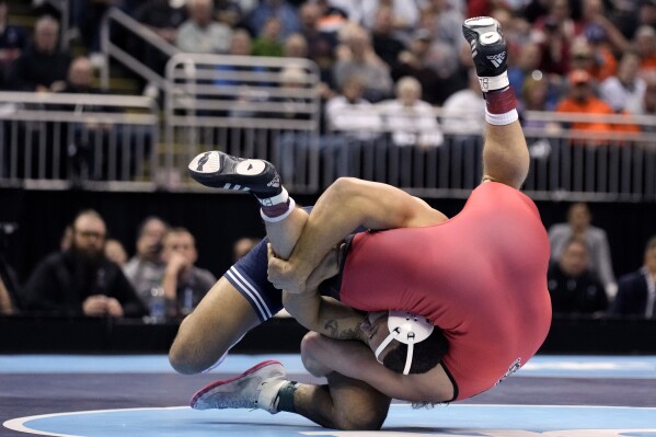 Penn State's Aaron Brooks, left, takes on NC State's Trent Hilday in their 197-pound match in the finals of the NCAA wrestling championships, Saturday, March 23, 2024, in Kansas City, Mo. (AP Photo/Charlie Riedel)