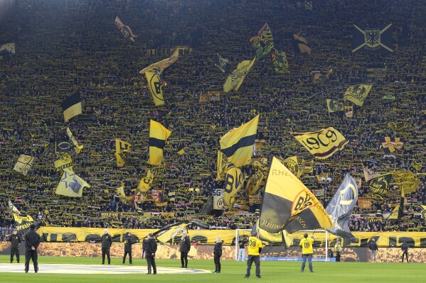 Dortmund supporters wave flags before the German Bundesliga soccer match between Borussia Dortmund and TSG Hoffenheim in Dortmund, Germany, Sunday, Feb. 25, 2024. (AP Photo/Martin Meissner)