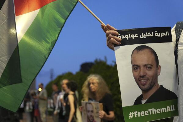 CORRECTS TO REFLECT LAWYER IS A WOMAN NOT MAN -- FILE - Protesters gather outside the hospital where Khalil Awawdeh, pictured in placards, a Palestinian prisoner in Israel is on hunger strike, in Be'er Yaakov, Aug. 13, 2022. Arabic on the placard: "Freedom for Khalil Awawdeh." Ahlam Haddad, Awawdeh’s lawyer, says her client will appeal his case to Israel's Supreme Court as he continues a 165-day hunger strike protesting being held without charge or trial under what Israel refers to as administrative detention. Haddad said his client is in a life-threatening situation. The Islamic Jihad militant group demanded his release as part of an Egyptian-brokered cease-fire to recent fighting in Gaza. (AP Photo/Tsafrir Abayov, File)